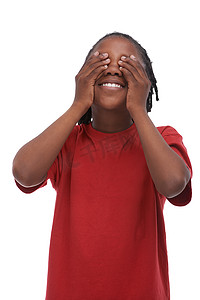 小孩眼睛摄影照片_不要偷看……一个年轻的非裔美国男孩站在白色背景下遮住眼睛。