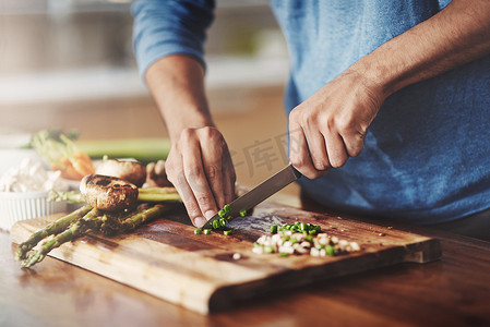 男人在厨房做饭的特写镜头，用新鲜蔬菜准备食物。