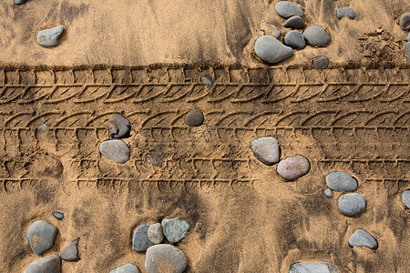 沙石logo摄影照片_沙石海滩上的汽车轮胎足迹