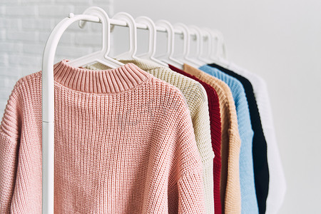 五彩的衣服摄影照片_衣架上挂着五彩女式羊毛衫。