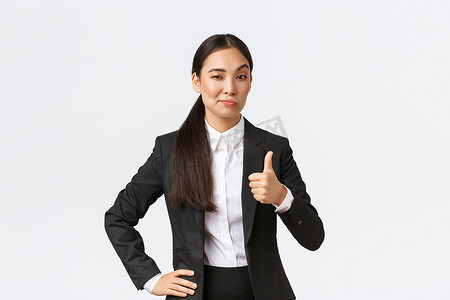 高兴的女企业家，穿黑西装的女老板对你的工作感到满意，竖起大拇指，点头赞同，称赞干得好，干得好，站在白色背景