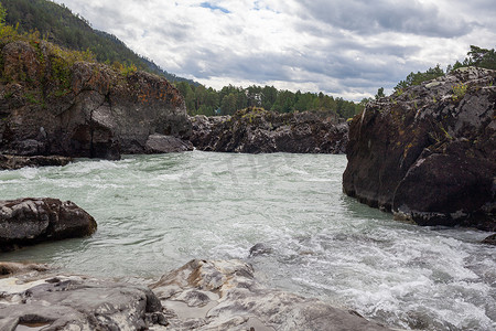 瀑布水流摄影照片_一条水流湍急、宽阔、水流充足的山间河流。