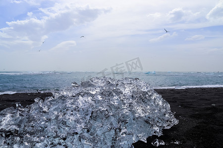 冰岛的钻石海滩，蓝色的冰山融化在黑色的沙滩上，冰在阳光下闪闪发光。