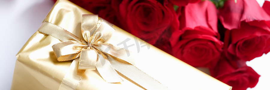 用金包裹的礼物和一束红玫瑰
