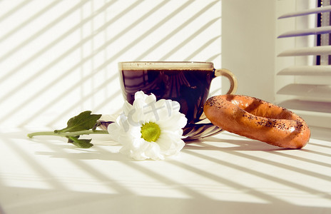 一杯热咖啡和窗台上的一朵花