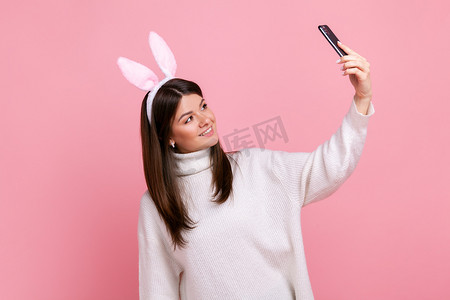 带兔耳的黑发女性侧视肖像直播或进行视频通话。