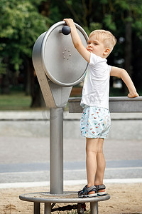 一个小男孩在城市公园玩水泵