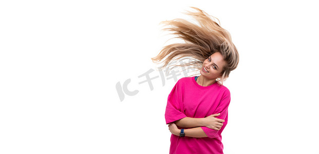 白色背景中一位身穿紫红色 T 恤、头发在风中飘扬的开朗年轻女子的肖像