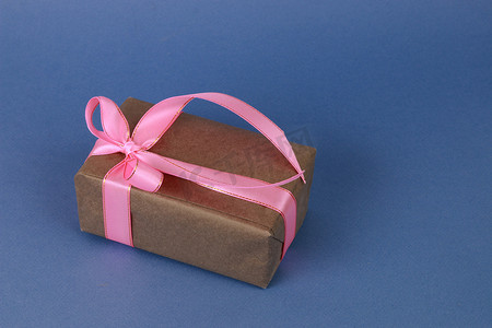 带粉色蝴蝶结的棕色礼品盒。