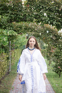 临夏民族大剧院摄影照片_乌克兰金发女孩穿着民族蓝色连衣裙 - 绣花衬衫。