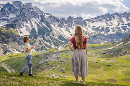 黑山美丽的杜米托尔国家公园的山湖景观中的游客母子家庭，有湖冰川和反射山