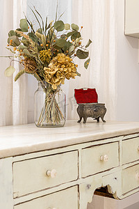 一束干花和复古首饰盒放置在复古风格的家具上。