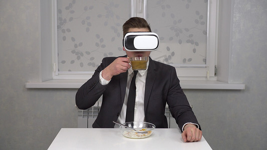 一名身穿西装、戴着 VR 头盔的年轻人正在吃麦片、喝咖啡。