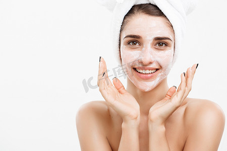 美容护肤概念-美丽的白种女人脸部肖像在她的面部皮肤白色背景上应用奶油面膜。