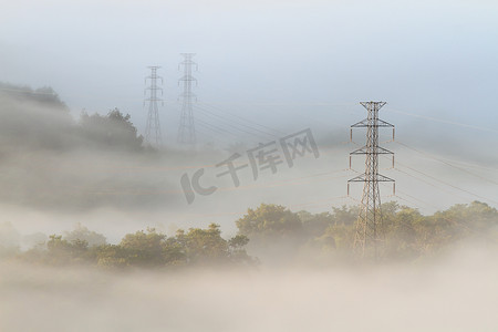 网格出现摄影照片_从雾中出现的电线和塔