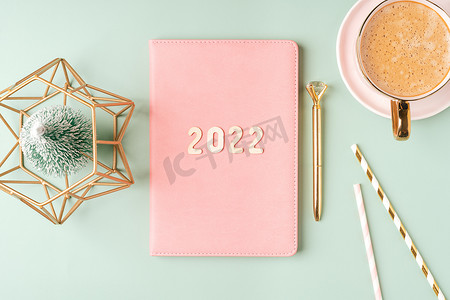 顶视图桌面圣诞粉色记事本，上面有 2022 年字母文本。