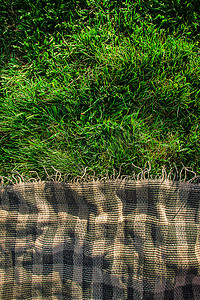 绿色格子布摄影照片_格子布适合在草地上野餐。