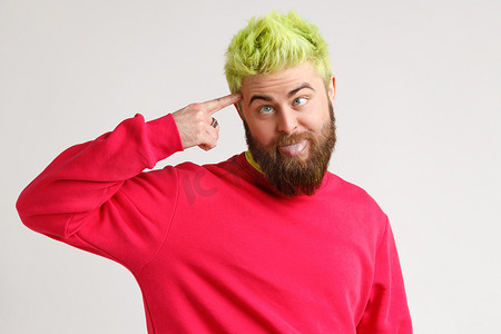 愚人摄影照片_时髦的情感男人与绿色的头在灰色的背景。