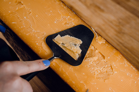 使用切片刀将陈年帕尔马干酪与晶体切片。