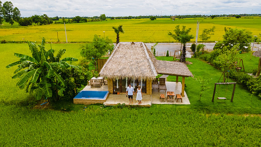 寄宿摄影照片_泰国中部有稻田的生态农场寄宿家庭，情侣在农场度假，男人和女人