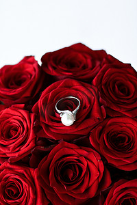 美容珍珠摄影照片_美丽的白金珍珠戒指和红玫瑰花束、奢华珠宝情人节和浪漫假期的爱情礼物