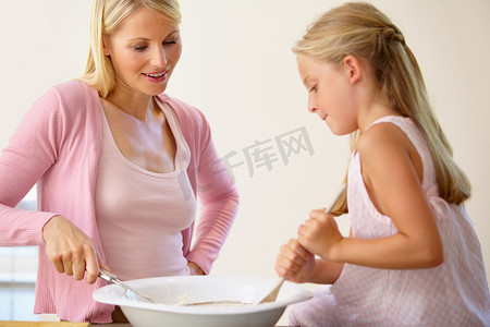 面糊摄影照片_它只缺少一件事……一对母女在烘烤时一起搅拌一碗面糊。