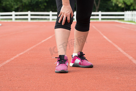 中年女子跑步者在户外训练时膝盖疼痛。