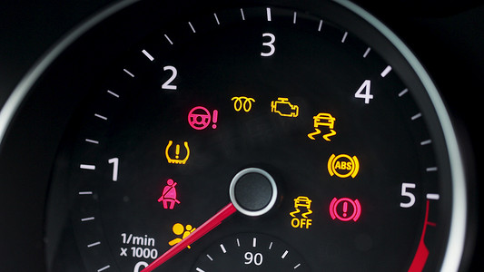 汽车仪表摄影照片_许多不同的汽车仪表板灯带有点亮的警告灯。