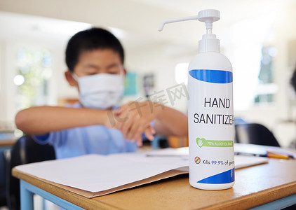 男孩在学校擦洗手液，以确保卫生、安全和预防新冠病毒。