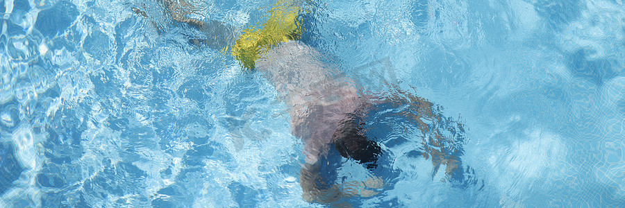 溺水演练摄影照片_躺在游泳池底部的男人顶视图