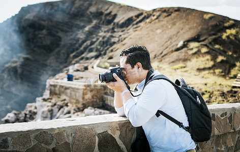 旅游景点拍照摄影照片_游客在火山观景点拍照的特写。