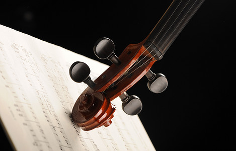 红色乐谱摄影照片_乐谱上小提琴的优雅镜头