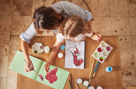 母婴工作室摄影照片_在家庭工作室、家庭住宅或创意空间中用画笔、油画或书籍进行顶视图、母婴艺术绘画。