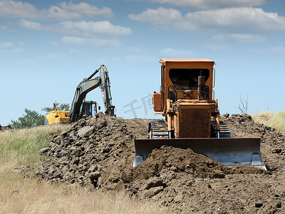 机器搬运摄影照片_道路施工中的推土机和挖掘机
