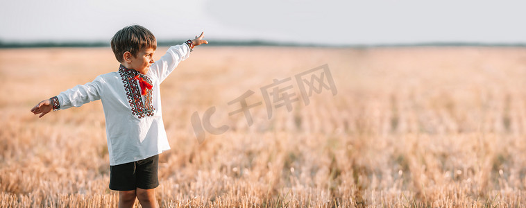 爱国小报摄影照片_横幅，复制空间，快乐的男孩 — 乌克兰爱国儿童在收集小麦后，张开双臂作为飞机在田野里，空地。