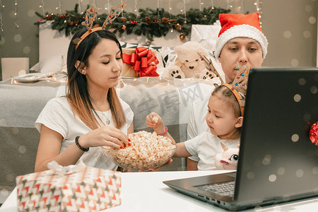 舒适的家庭圣诞节，在笔记本电脑上观看视频，在电影之夜或通过视频链接一起享受快乐的乐趣和圣诞假期
