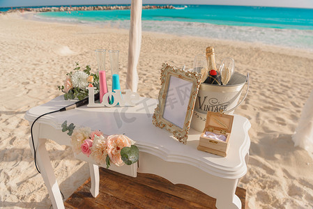 综艺表情装饰摄影照片_婚礼用的白色桌子，在海边有装饰。