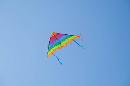 在炎热的夏日，五颜六色的风筝在蓝天上飞翔着尾巴。