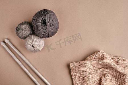 织毛衣的针摄影照片_由灰色纱线毛衣和用于针织特写镜头的线编织而成。