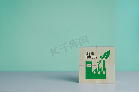 带有工业工厂图标和绿色工业字体的木制立方体。