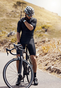 男性自行车手在山路上骑自行车或训练时因运动损伤而按住肩膀疼痛。