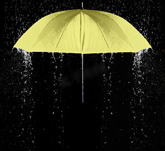 雨滴下的黄色伞有黑色背景
