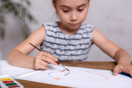 桌上有灵感的小女孩用颜料画画