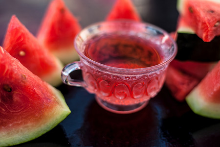 西瓜冰西瓜冰摄影照片_木质表面透明玻璃杯中的西瓜籽果冰茶以及​​三角形西瓜片。