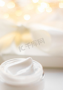 假日闪光背景的面霜保湿罐、保湿护肤品作为提升乳液、豪华美容护肤品牌的抗衰老化妆品