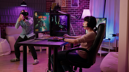 玩家女孩在动作空间模拟游戏中庆祝胜利，而男友正在玩虚拟现实第一人称射击游戏