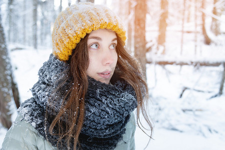 冬季的心情摄影照片_年轻漂亮的白人女性的照片肖像，快乐的积极微笑，冬季公园里愉快的好心情，望向别处。