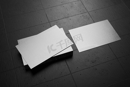 白色水平名片纸样机模板，带有空白空间封面，用于在黑色纸板地板背景上插入公司徽标或个人身份。
