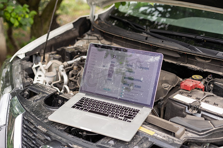 服务汽车发动机机器概念，汽车机械修理工在修理、汽车服务和维护时使用计算机诊断检查汽车发动机。