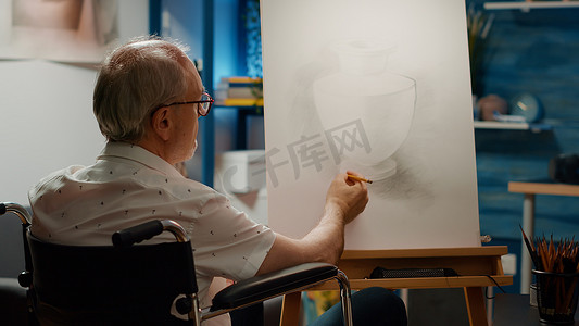 男性轮椅使用者在画布上绘制花瓶设计草图